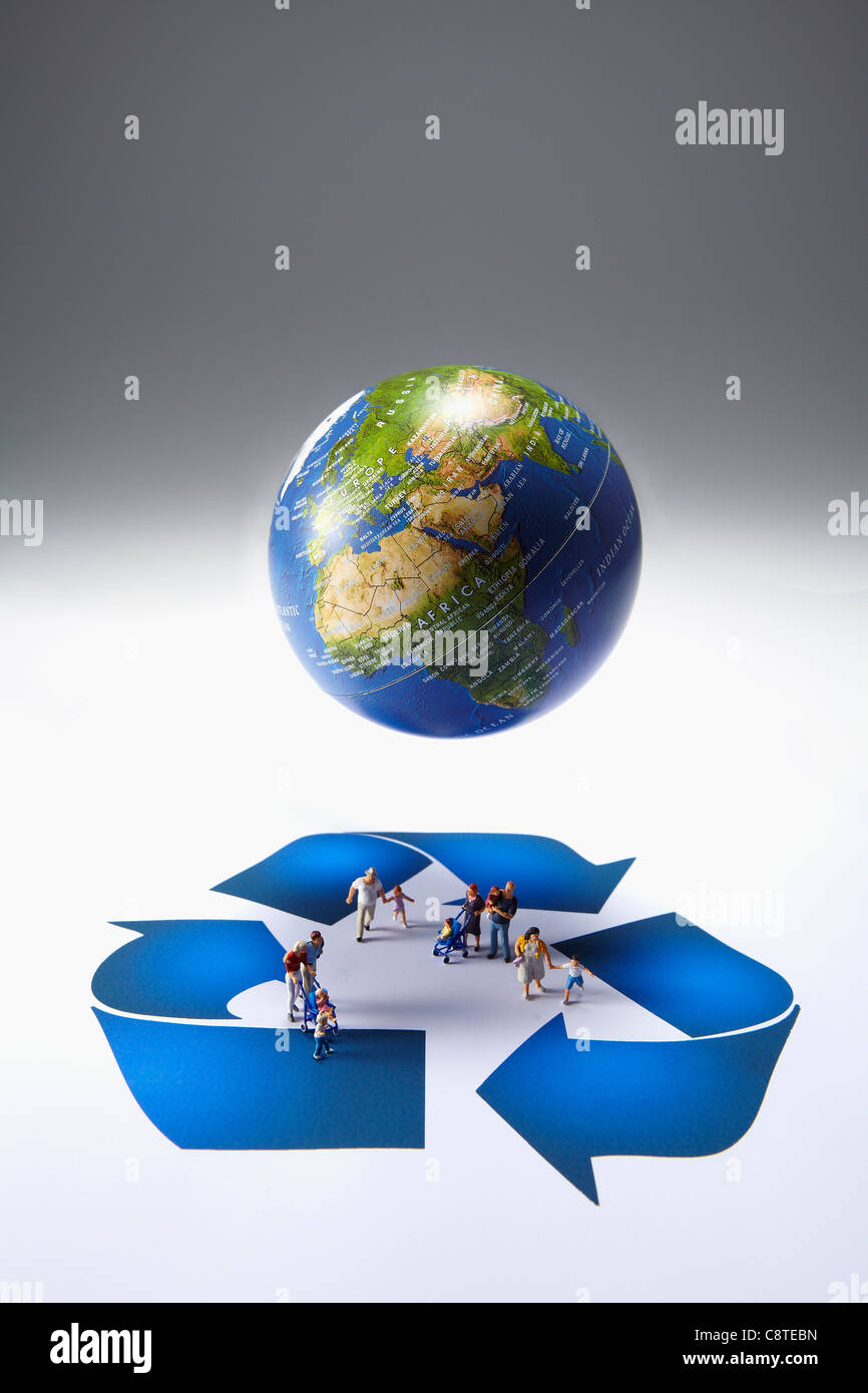 Erhöhte Ansicht des Globus mit kleinen Figürchen und recycling-Symbol auf grauem Hintergrund Stockfoto