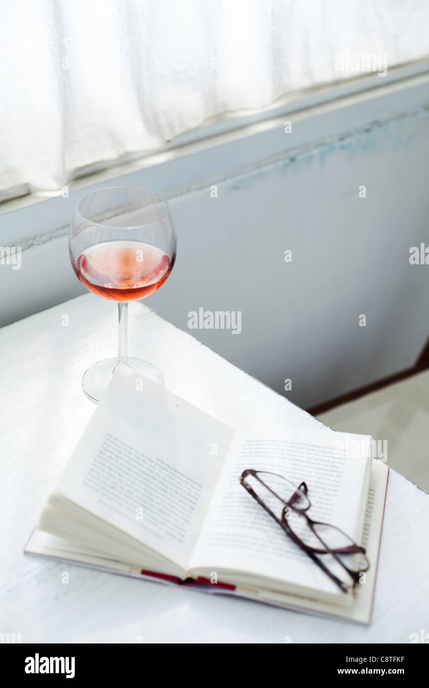 Nahaufnahme von Weinglas in der Nähe von Gläsern auf ein Buch Stockfoto
