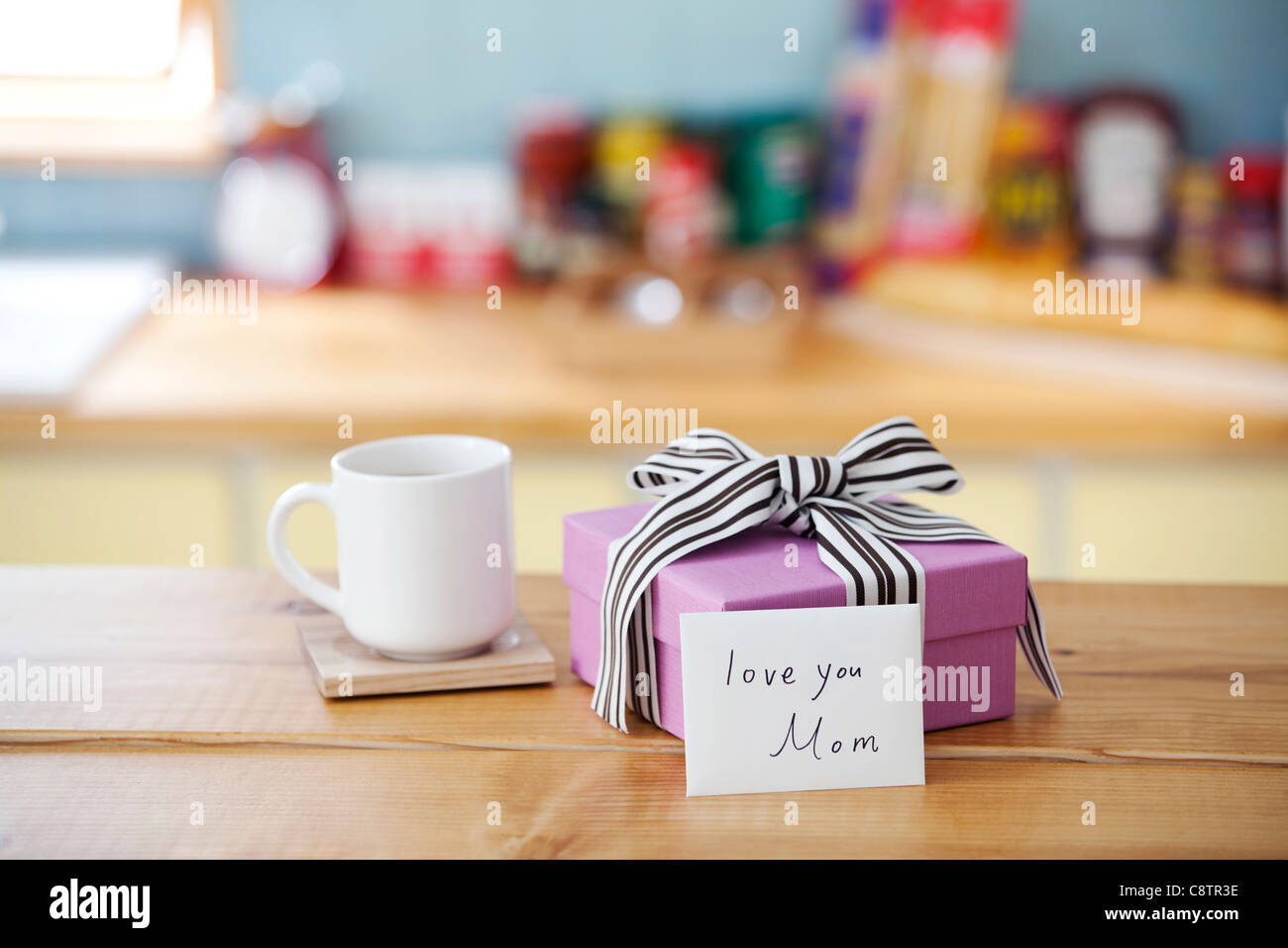 Verpacktes Geschenk-Box und Kaffee-Haferl auf Küchentisch Stockfoto