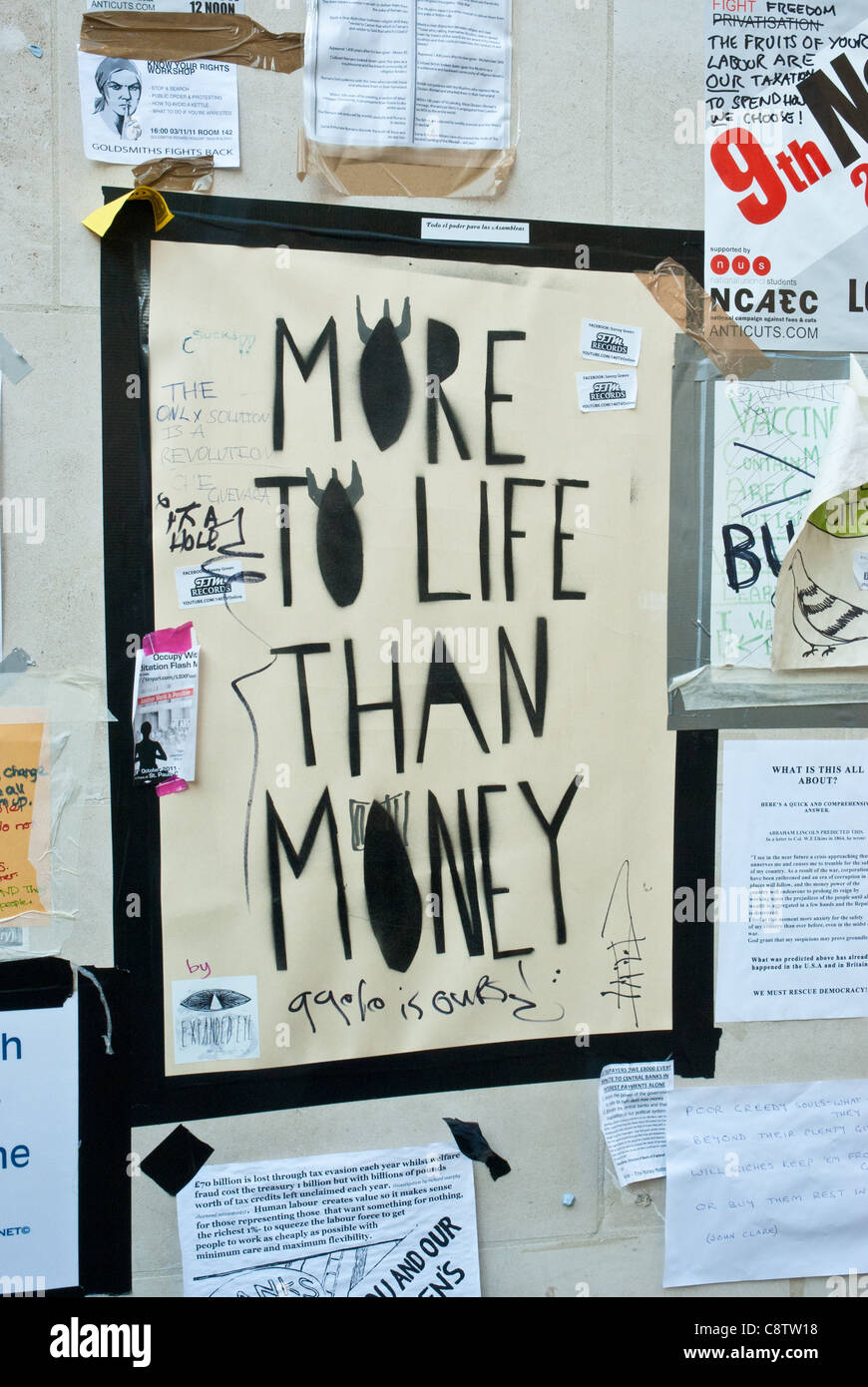 London [St Pauls] Poster an Wand "mehr im Leben als Geld" zu besetzen (Buchstabe o geformt als Bomben) Stockfoto