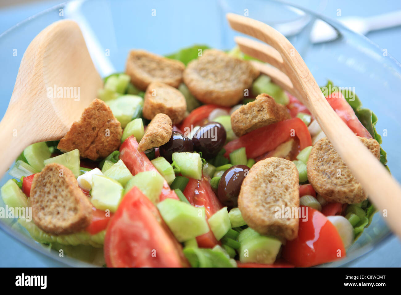 Salat in eine Glasschüssel mit Tomaten, Gurken, Oliven und croutons Stockfoto