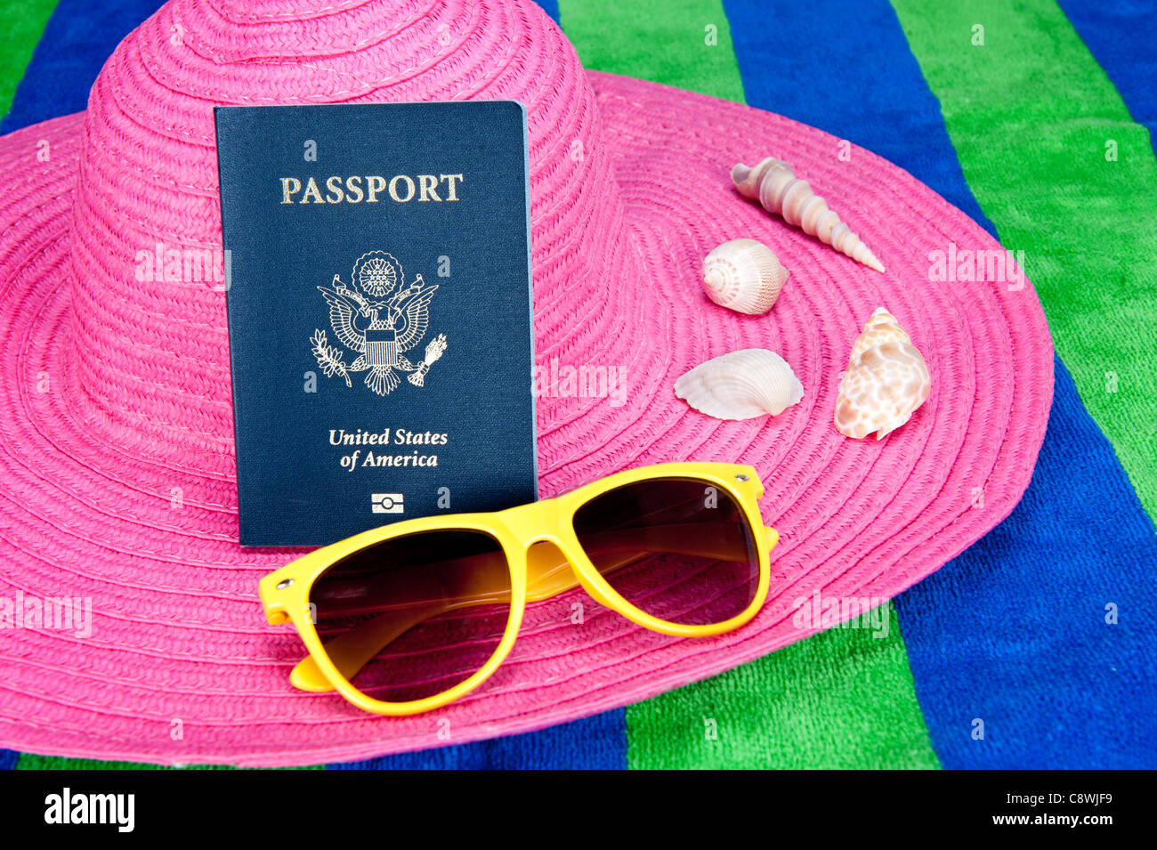 Einen Pass auf einen rosa Tourist-Hut mit gelben Sonnenbrillen und Muscheln Stockfoto