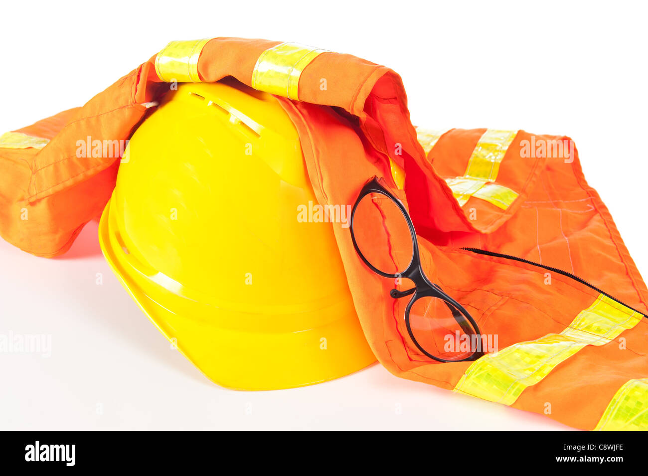 Schutzhelm, orange Warnweste und Schutzbrille auf weiß. Stockfoto
