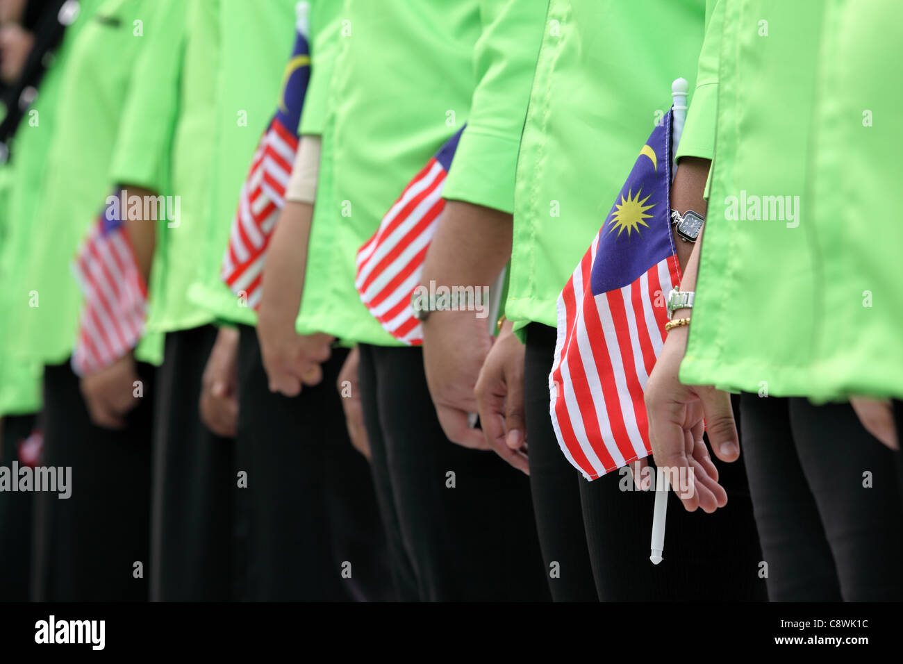 Frauen in Uniform, die malaysische Fahnen während Melaka Unabhängigkeitsfeierlichkeiten Tag zu halten. Melaka, Malaysia, Südostasien, Asien Stockfoto
