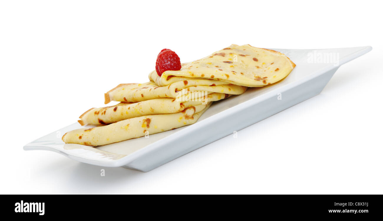 Krepp auf einem Teller mit einer Himbeere. Ein Detailfoto gebratene dünne Pfannkuchen. Isoliert auf weiss Stockfoto
