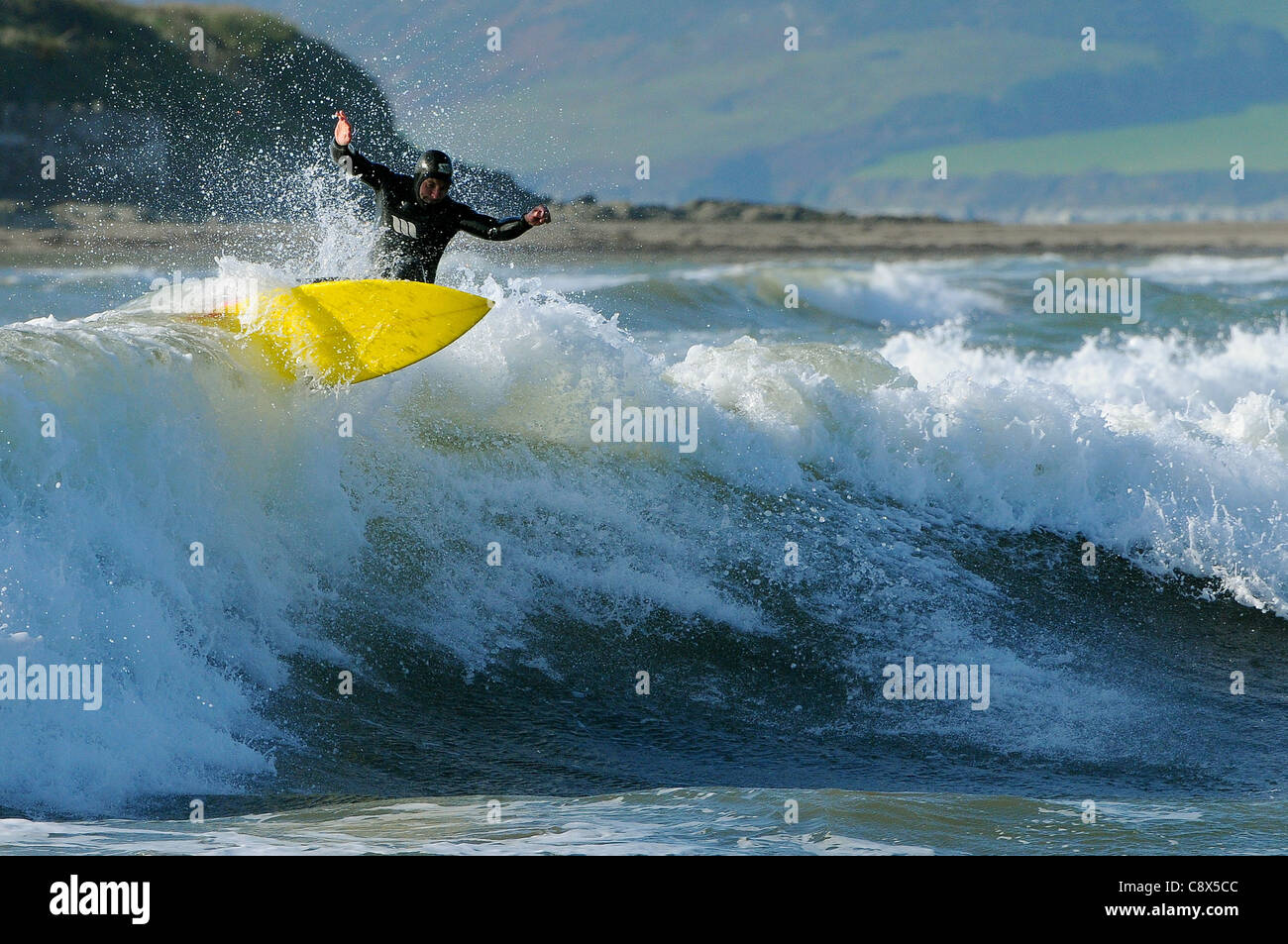 Eine Surfer reitet eine Welle Größe Strand in Devon im November. Stockfoto