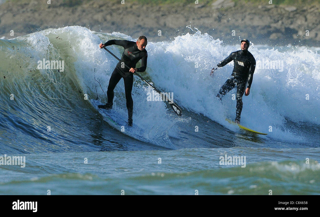 Eine Surfer schreit ein Paddel-Boarder dafür seinen Platz auf einer Welle. Stockfoto