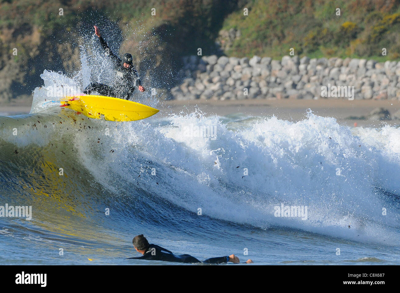 Eine Surfer reitet eine Welle Größe Strand in Devon im November. Stockfoto