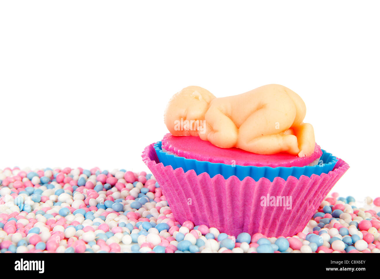 Geburt-Cupcake mit Marzipan Baby und bunten Mäuse Süßigkeiten auf weißem Hintergrund Stockfoto