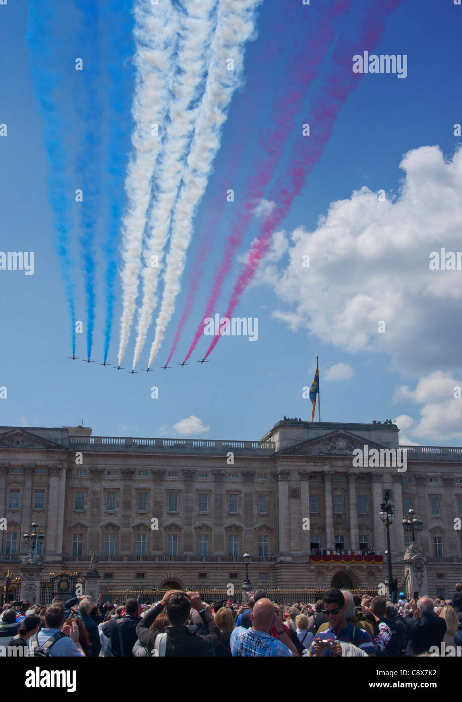 Trooping die Farbe Red Arrows fliegen vorbei an Buckingham Palace mit roten, weißen und blauen Kondensstreifen Himmel London England UK Stockfoto