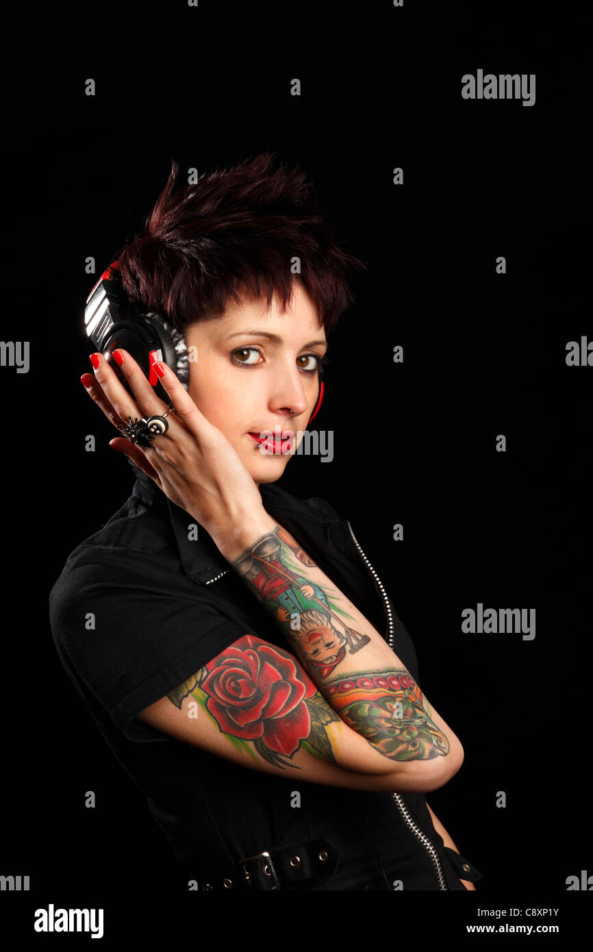 Junge Frau Mit Tattoos Auf Dem Arm Das Anhoren Von Musik Uber Kopfhorer Stockfotografie Alamy