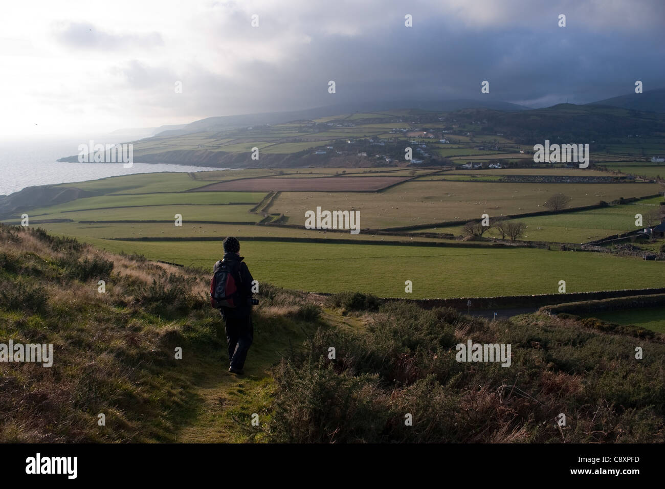Eine weibliche Walker absteigend aus Maughold Head auf der Isle Of Man Stockfoto
