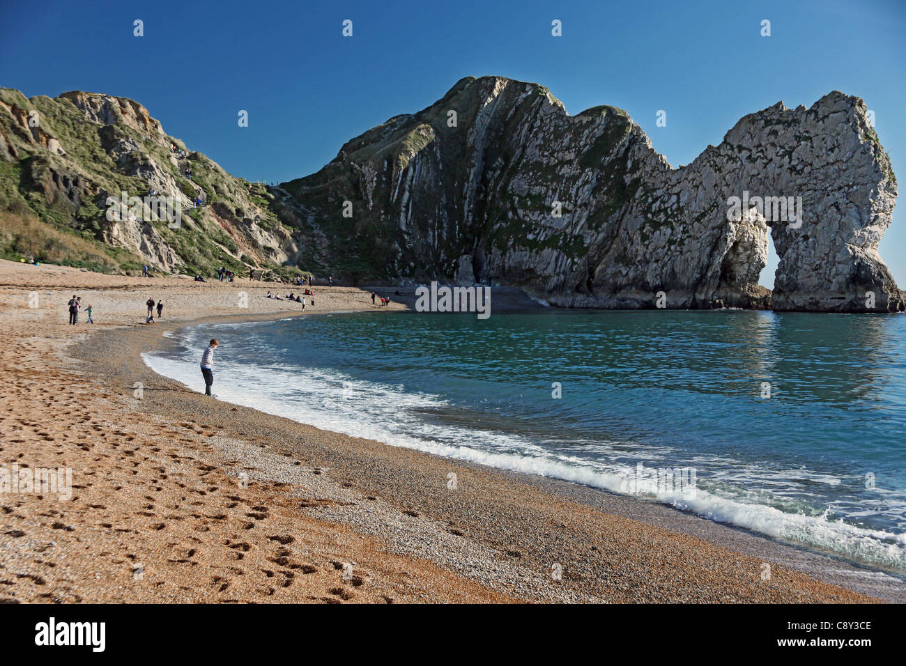Menschen am Strand unterhalb Durdle Door - ein natürlicher Bogen auf der World Heritage Coast in Dorset England UK Stockfoto