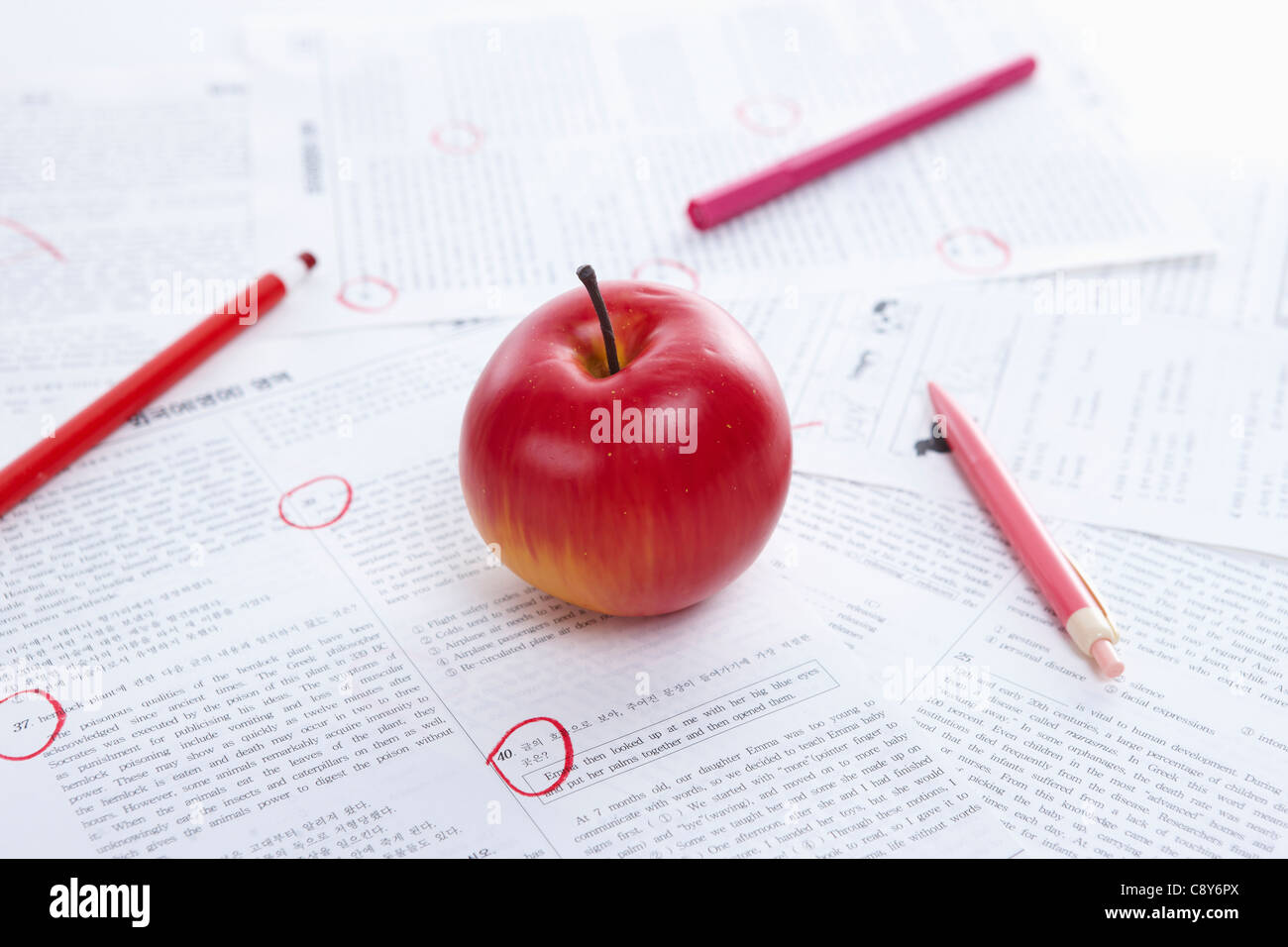 Markierten Testpapiere mit Farbstiften und Apfel Stockfoto