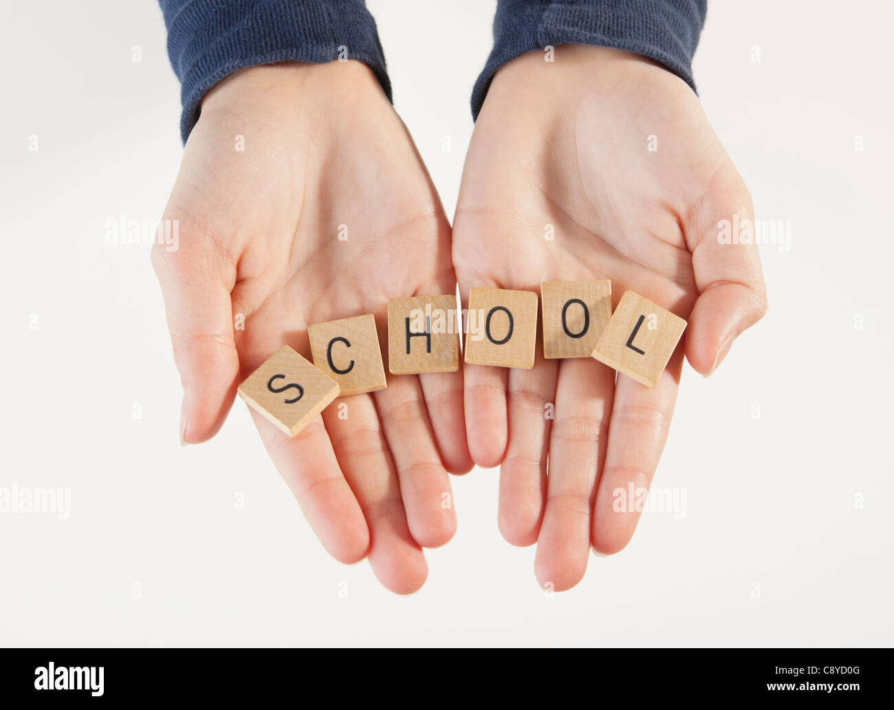 Blöcke mit Buchstaben "Schule" des jungen (10-11) Hände, Studio shot Stockfoto