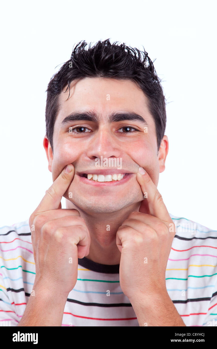 Junger Mann mit lustigem Gesicht mit einem erzwungenen Lächeln (isoliert auf weiss) Stockfoto