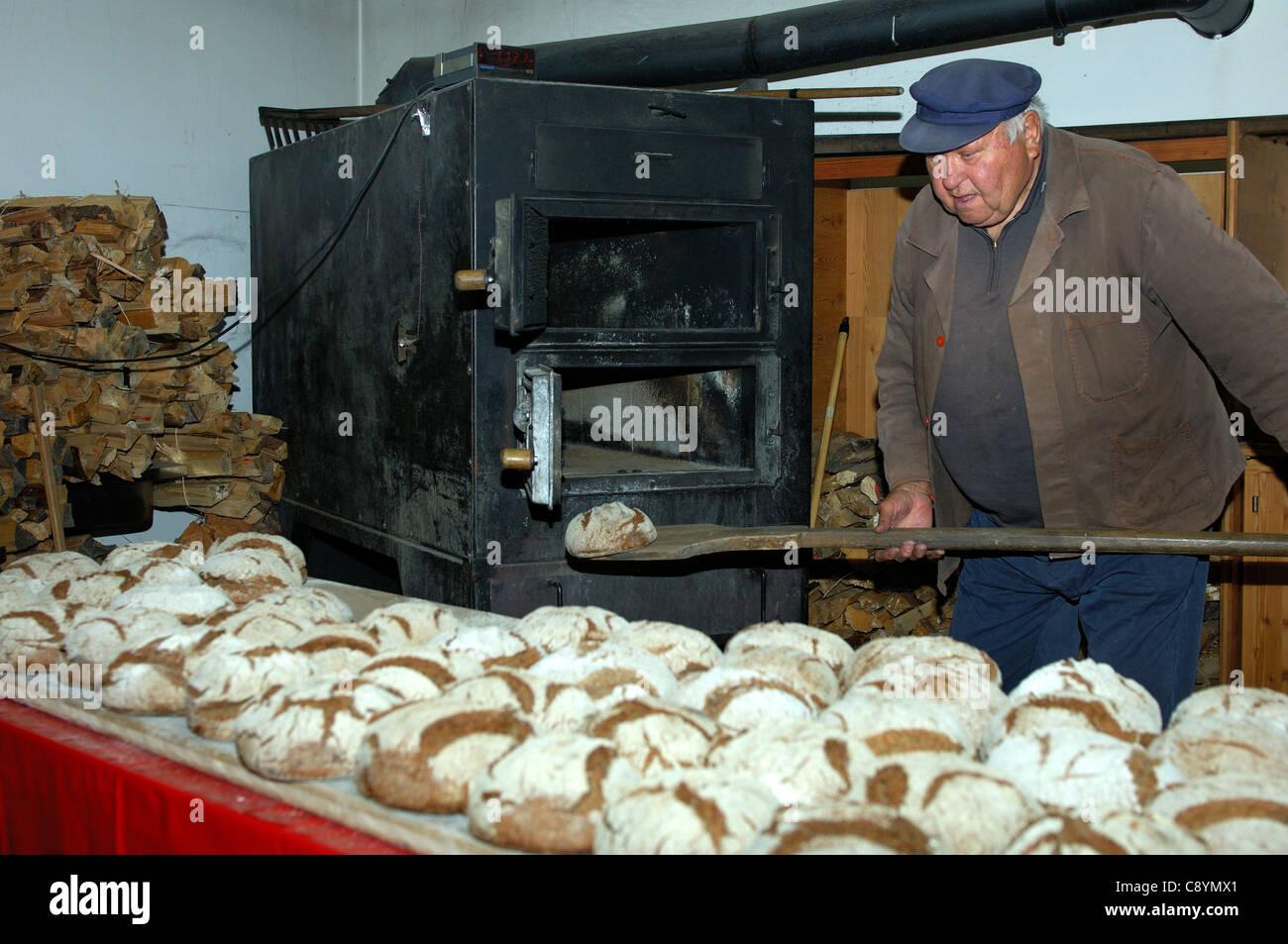 Baker, die Aufnahme von frisch gebackenen Walliser Roggen Brot aus dem Backofen der Dorfbäckerei in Erschmatt, Wallis, Schweiz Stockfoto