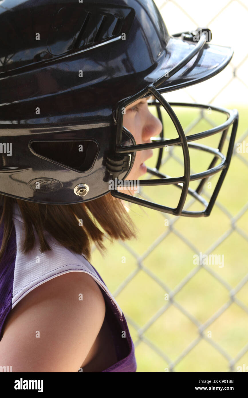 Mädchen am Softball-Spiel bevor sie steigt im Helm Fledermaus Stockfoto