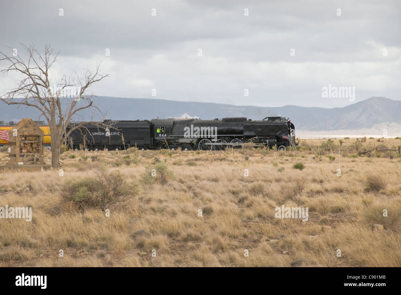 Bei bewölktem Himmel beschleunigt die Union Pacific Dampflok 844 bei 65 km/h auf einem kurzen Zwischenstopp in Carrizozo, New Mexico Stockfoto