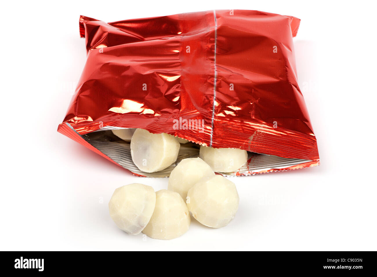 Weiße Schokolade aus einem roten Beutel verschütten Stockfoto