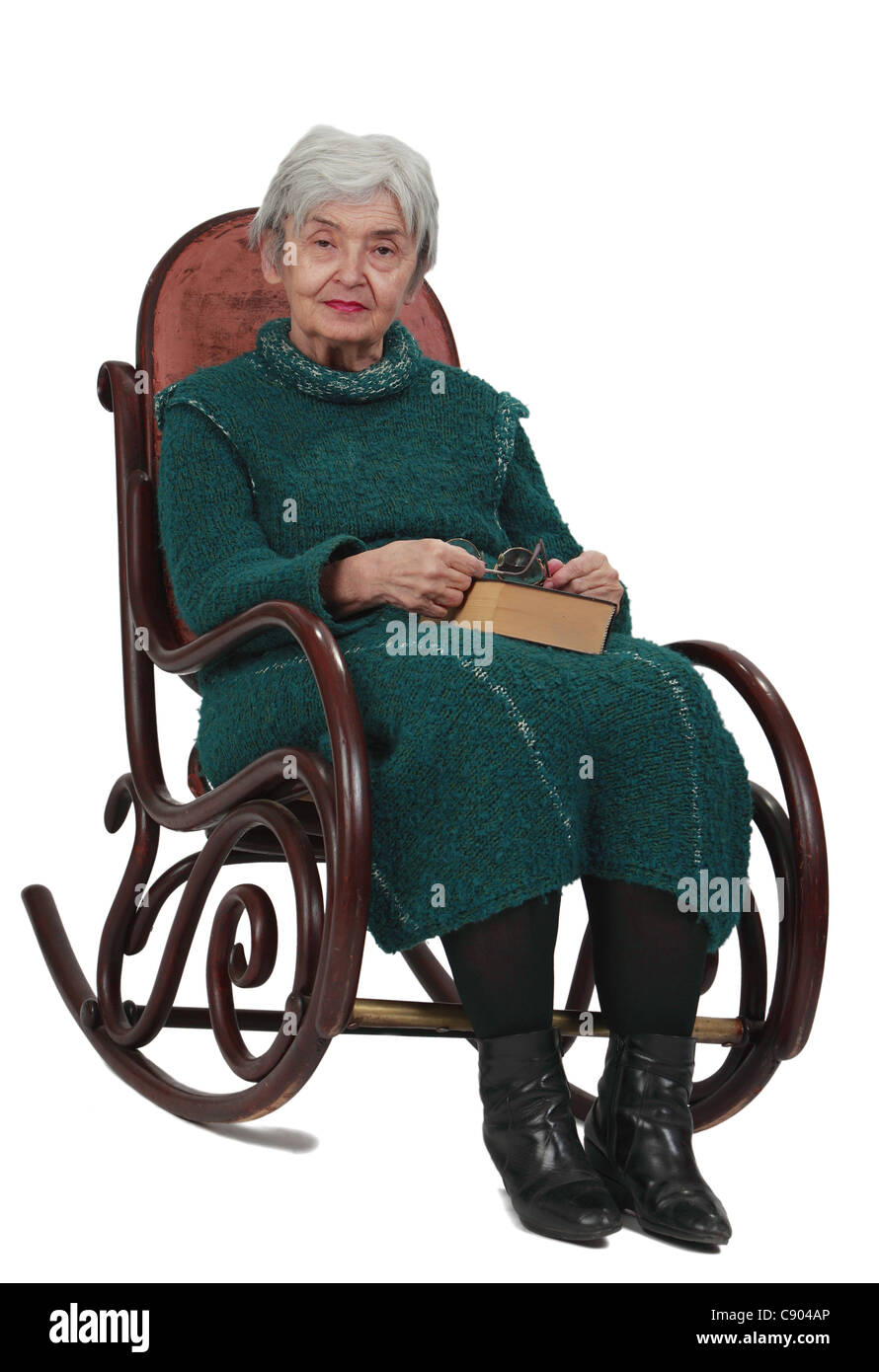 Bild einer alten Frau sitzen auf einer Wippe mit ein Buch mit sieben Siegeln in ihrem Schoß. Stockfoto