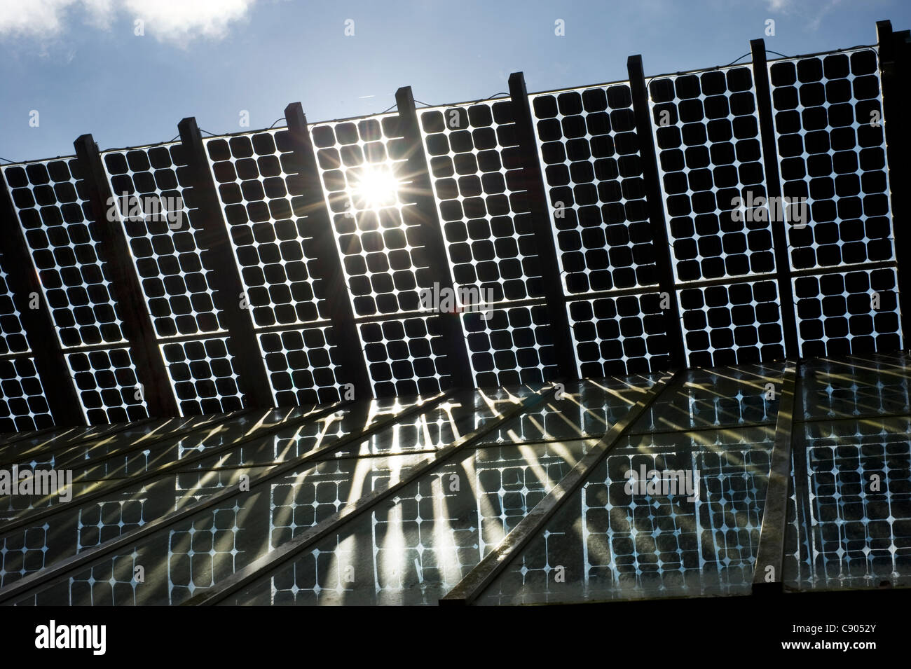 Die Sonne bricht durch das Innere der Solar Panals installiert auf dem Dach eines Gebäudes in der Mitte für Alternative Technologie, oder CAT, Europas führende Öko-Zentrum in Powys, Wales. Stockfoto