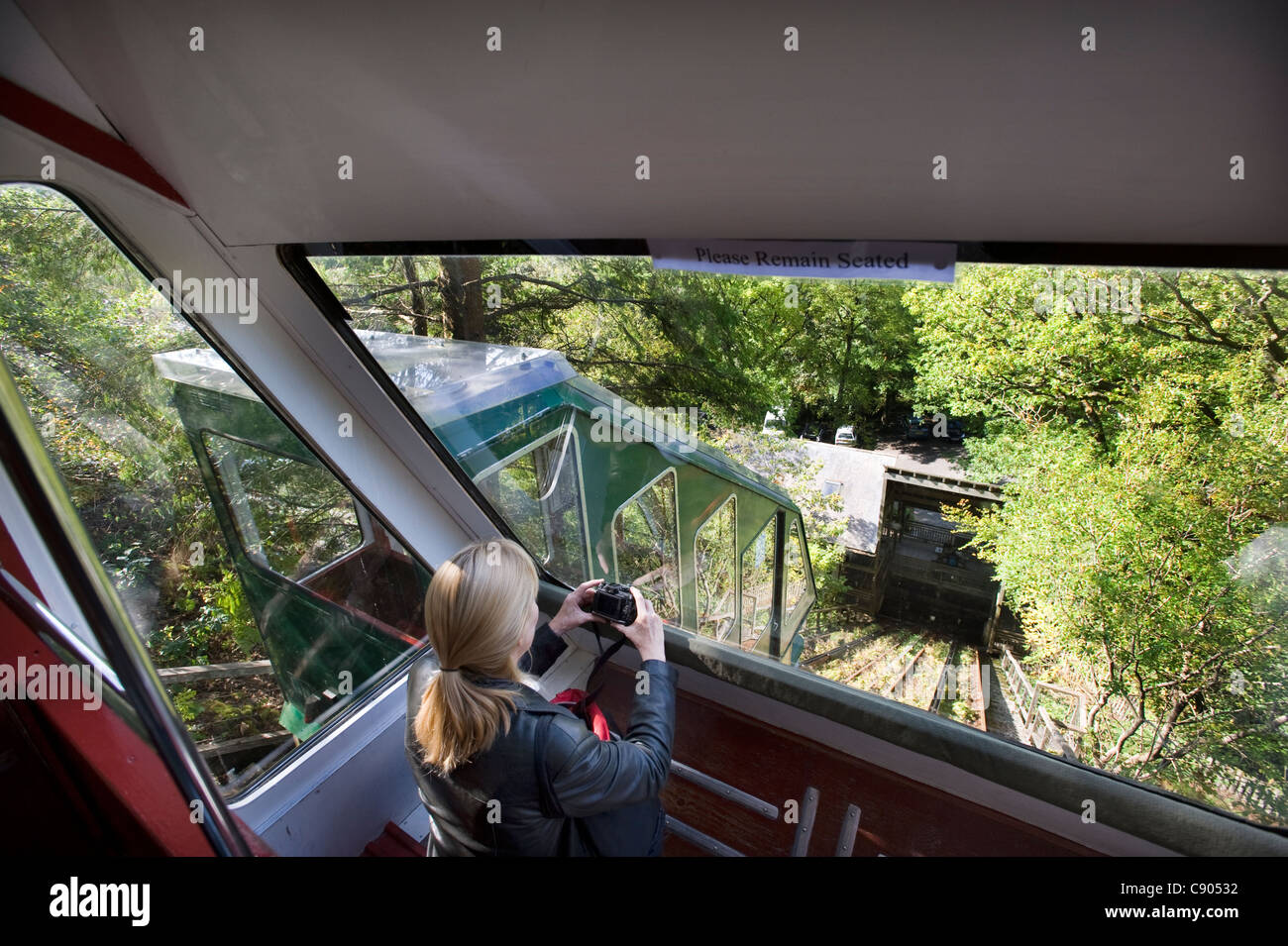 Ein weiblicher Touristen nimmt ein Foto aus einem der Autos auf der Wasser-ausgewogen Standseilbahn Cliff Railway, einer der steilsten Klippen Eisenbahn der Welt in der das Zentrum für Alternative Technologie in Nord-Wales Stockfoto