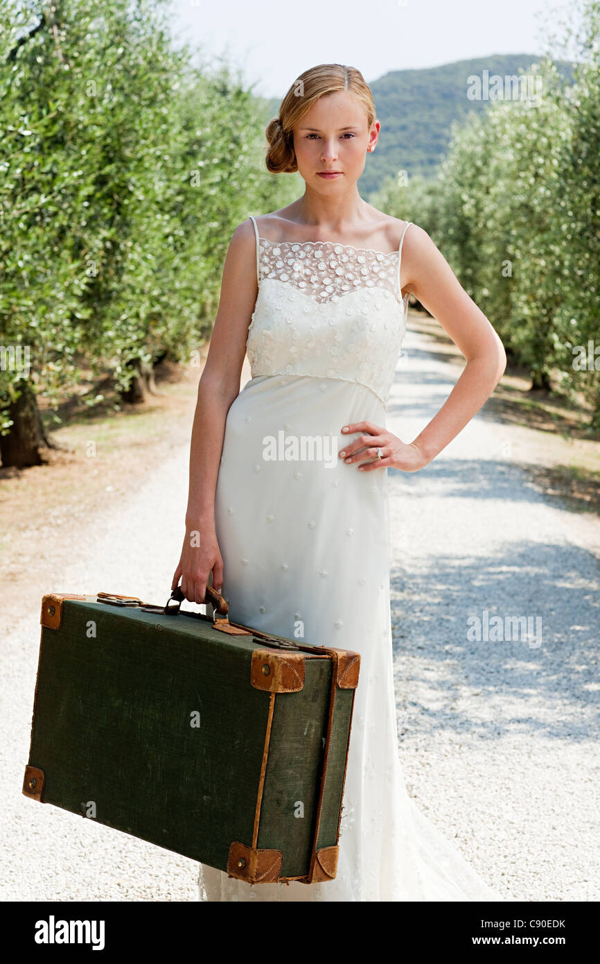 Braut mit Koffer auf Landstraße, hand, Hüfte Stockfoto
