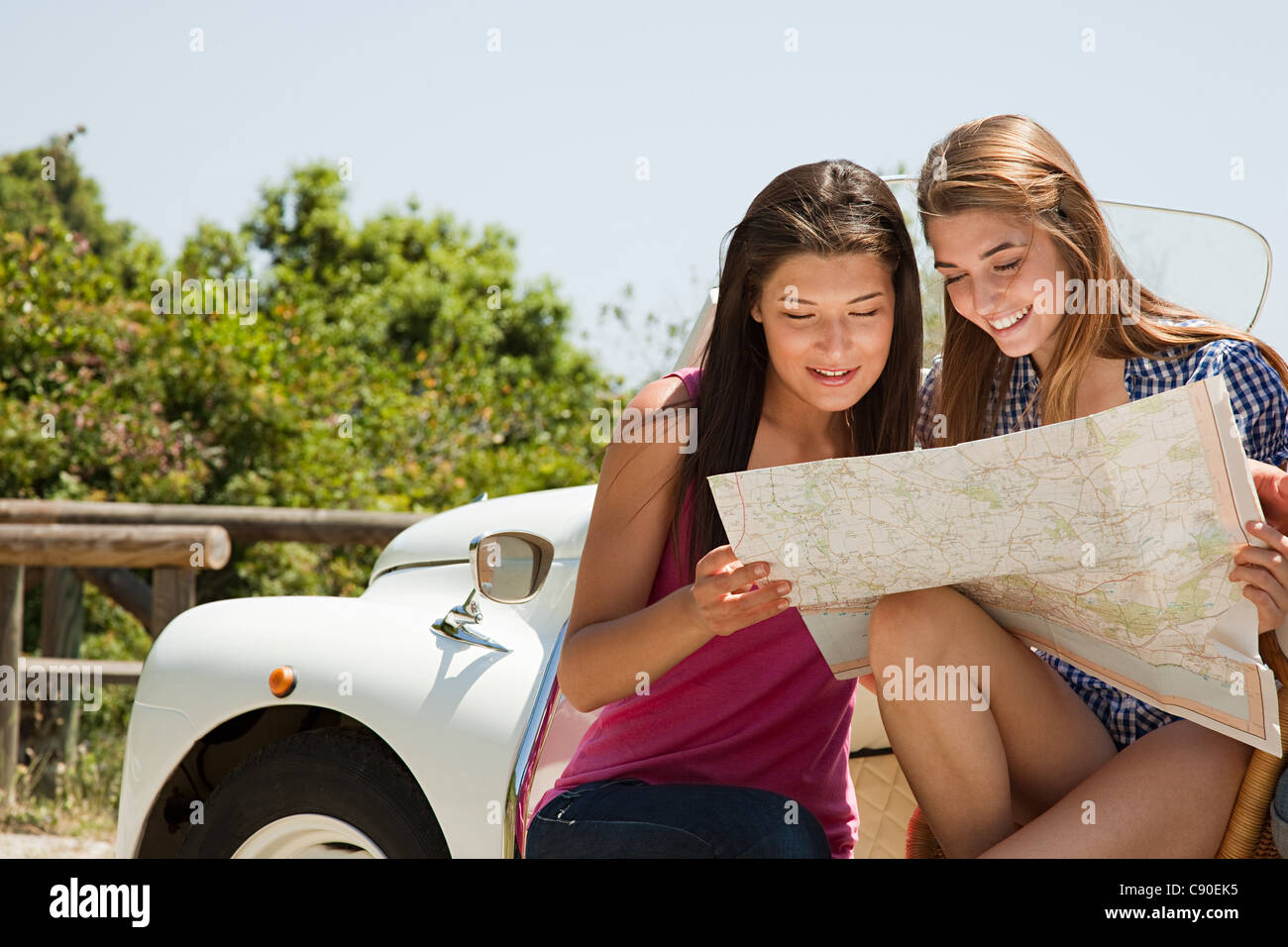 Junge Frauen mit Cabrio Blick auf Karte Stockfoto