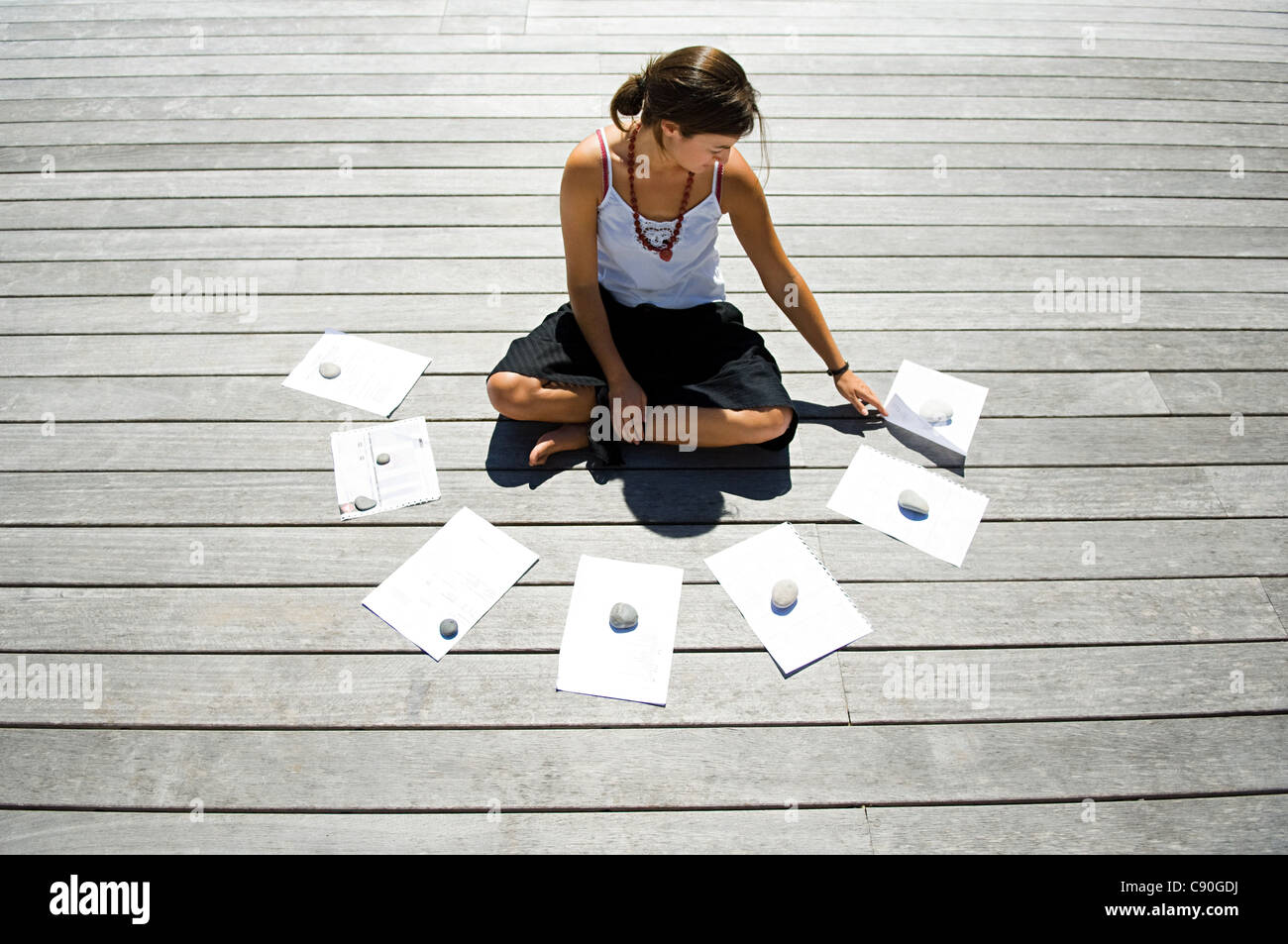 Frau sitzt auf decking Finanzunterlagen Stockfoto