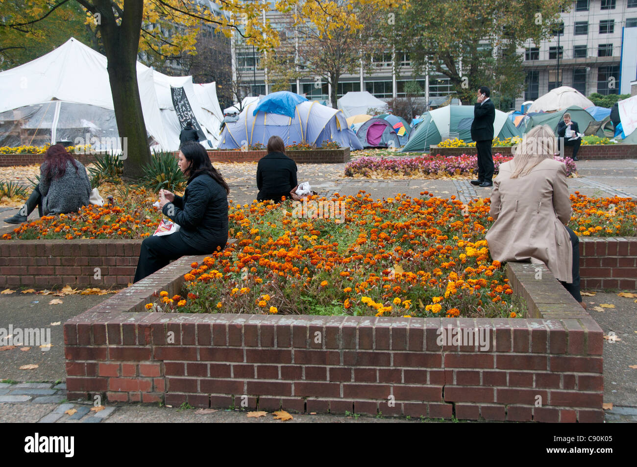 Occupy London Camp 3. November 2011 Finsbury Square. Stadtarbeiter beim Mittagessen mit Zelten im Hintergrund Stockfoto