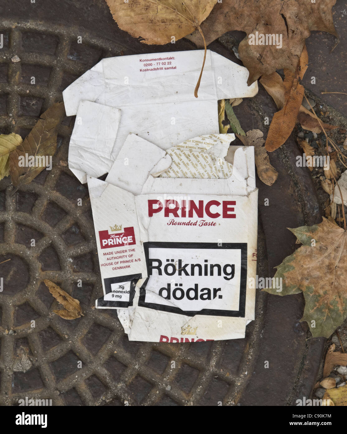 Leere Prinz Zigarettenschachtel auf den Boden getragen. Warnung vor Text auf Schwedisch "Rauchen ist tödlich." sagen. FÜR DEN REDAKTIONELLEN GEBRAUCH BESTIMMT. Stockfoto