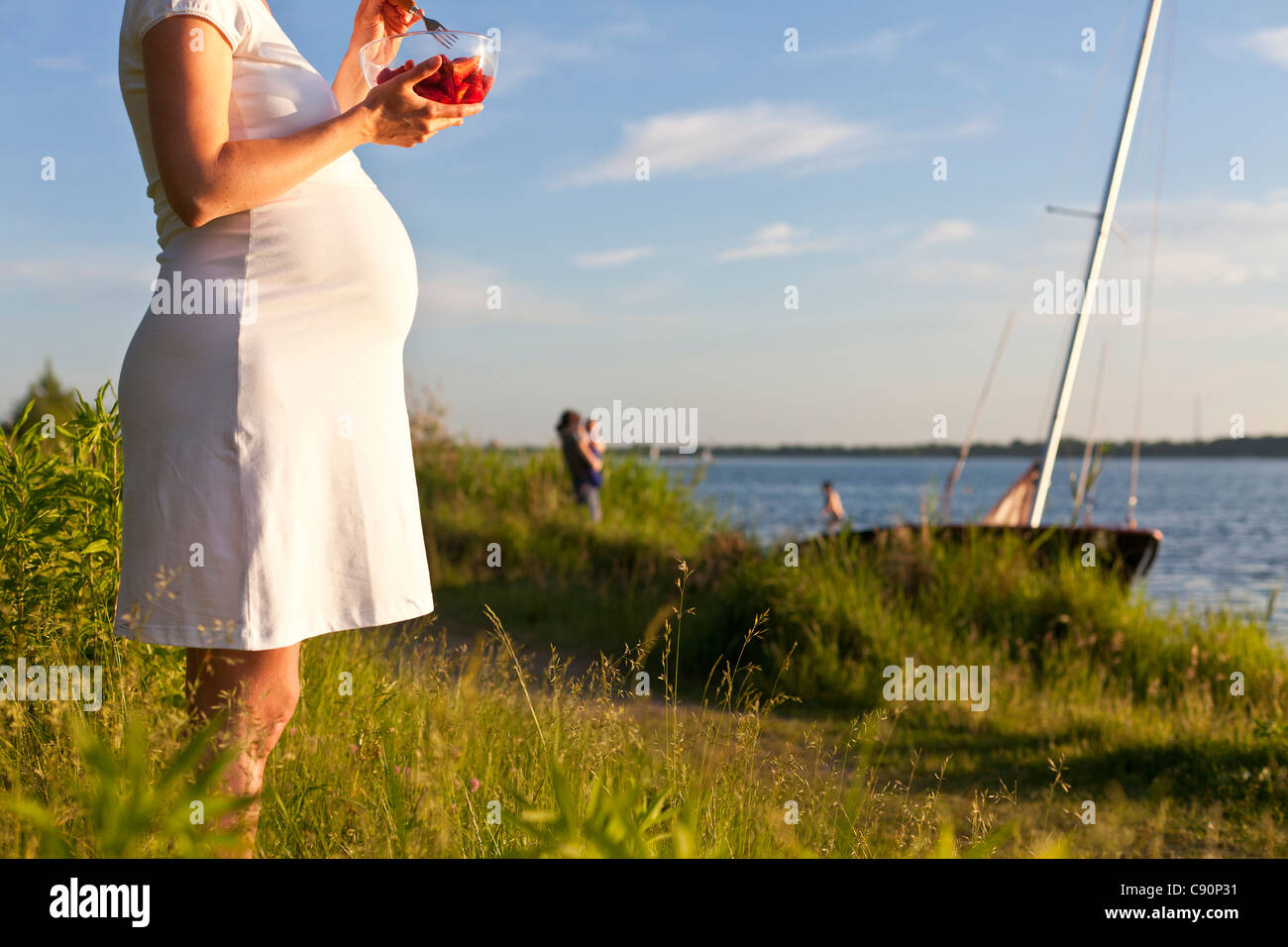 Schwangere Frau Essen Erdbeeren Cospuden See, Leipzig, Sachsen, Deutschland Stockfoto