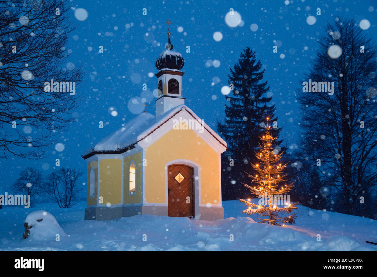 Kapelle mit Weihnachtsbaum bei Schneefall, Oberbayern, Deutschland, Europa Stockfoto