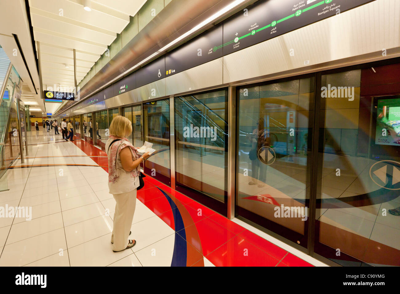 Frau liest ein Handbuch zur unterirdischen Plattform al Fahidi Metro Station Dubai, Vereinigte Arabische Emirate, Vereinigte Arabische Emirate, Naher Osten Stockfoto