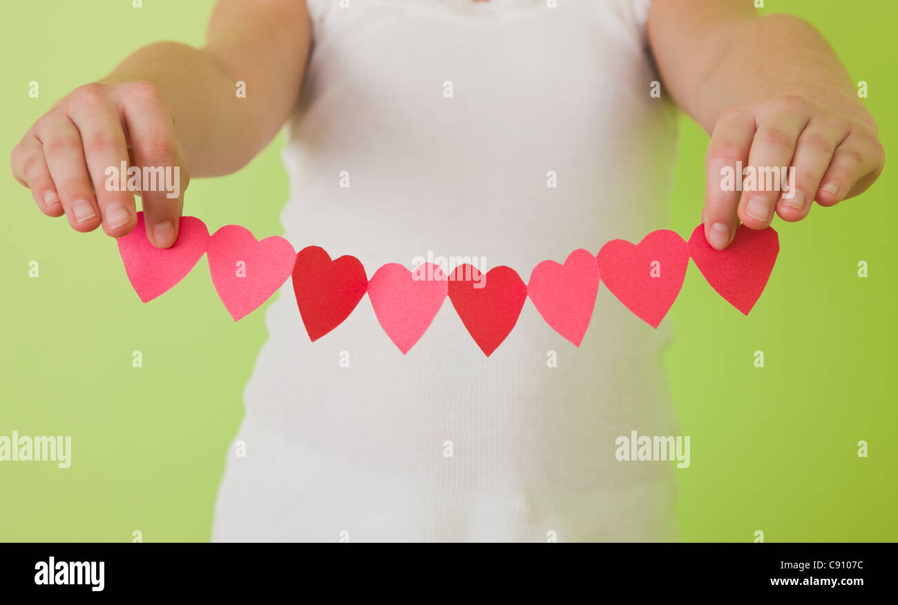Mädchen Herz (10-11) Holding Papier in Folge Stockfoto