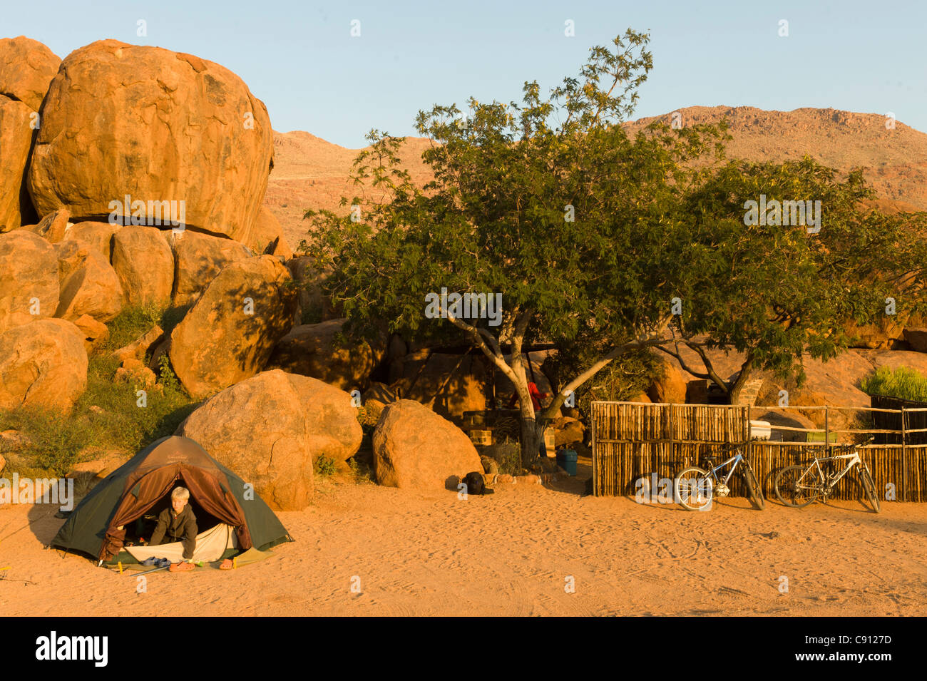 Junge klettern aus seinem Zelt auf Koiimasis farm Tiras Bergen Namibia Stockfoto