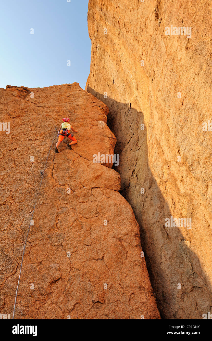 Frau Klettern am roten Felswand, große Spitzkoppe, Namibia Stockfoto