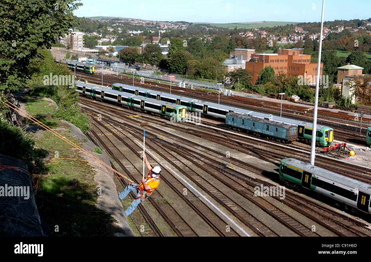 Team von Homegrown Holz Schiene Abseilstellen unten die Eisenbahn Böschungen in der Nähe von Bahnhof von Brighton Graffiti von Wänden UK reinigen Stockfoto