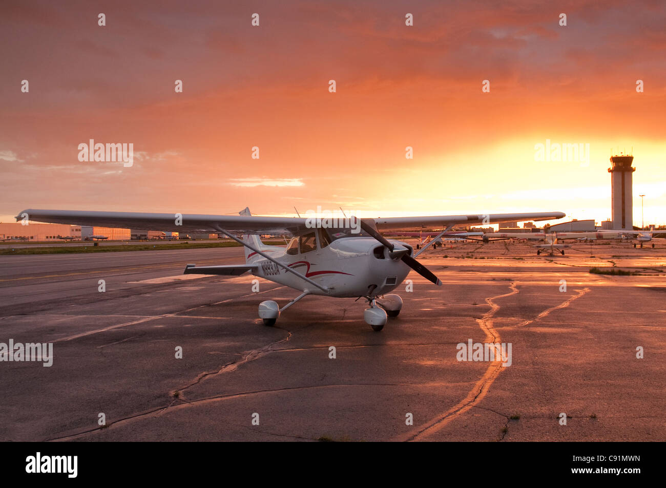 Die Sonne versinkt hinter einer Cessna 172 bei Merrill Field in Anchorage, Alaska Yunan, Sommer Stockfoto