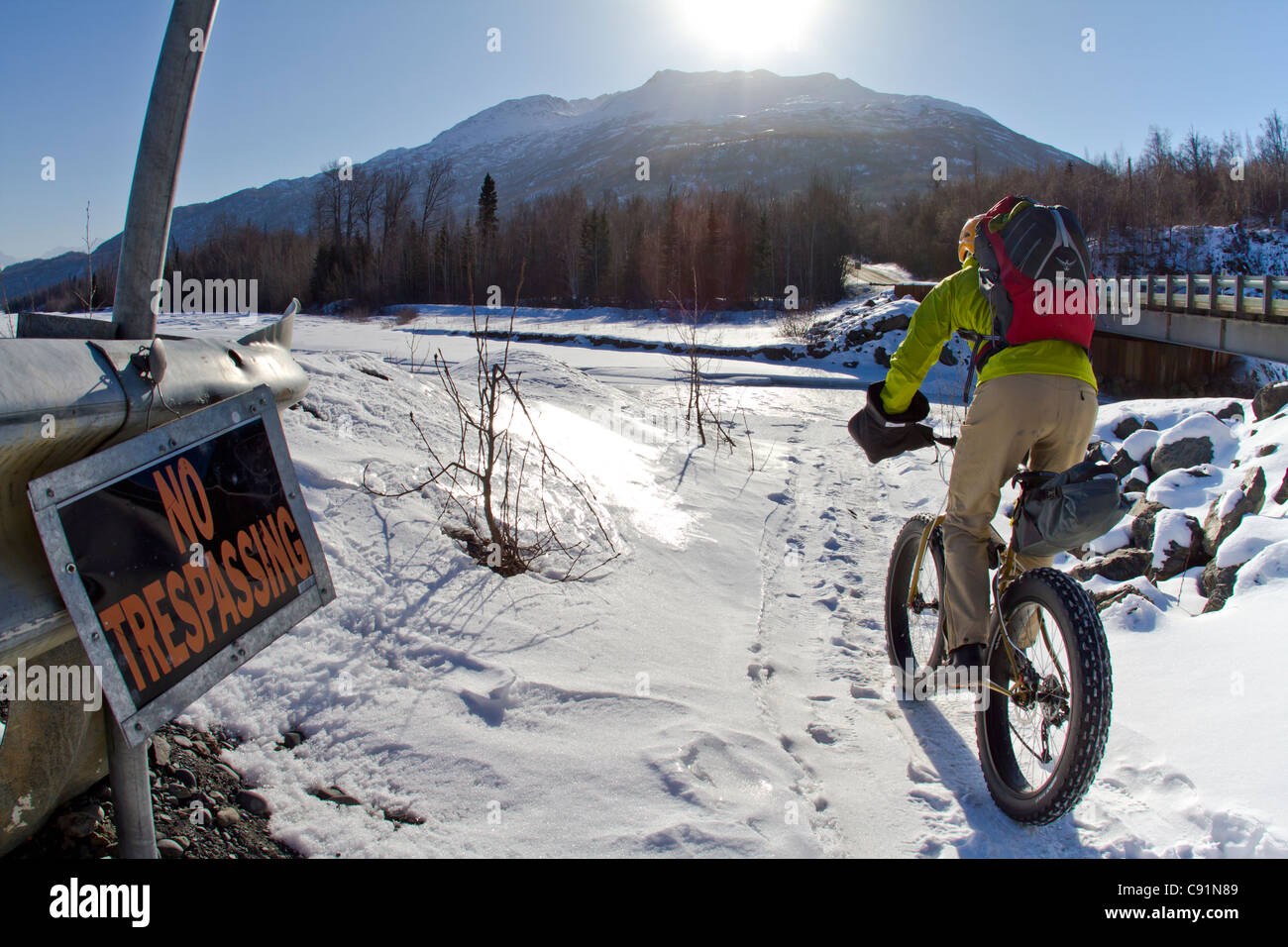 Mann Radfahren hinter einem No Trespassing Zeichen entlang der Knik River auf den Knik-Gletscher auf dem fetten Reifen Fahrrad, Chugach Mountains, Alaska Stockfoto