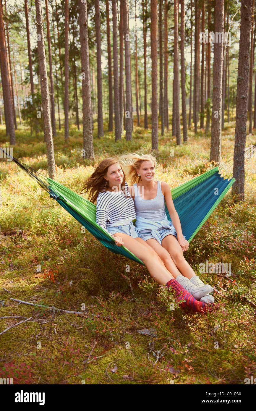Frauen, die zum Entspannen in der Hängematte im Wald Stockfoto