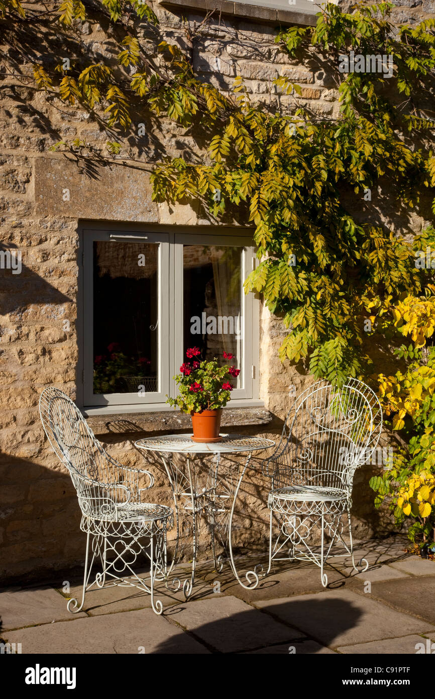 Metall französische Outdoor-Stühle und Tisch auf steinernen Terrasse im englischen Garten Stockfoto
