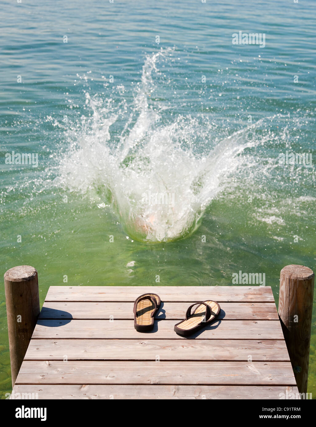 Flip Flops auf Holzterrasse See Stockfoto