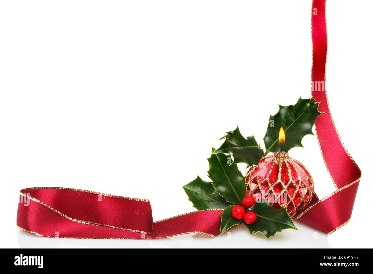 Ein Weihnachten Rahmen des Red Ribbon, eine dekorative Kerze und frischen Holly mit weißen Textfreiraum Stockfoto