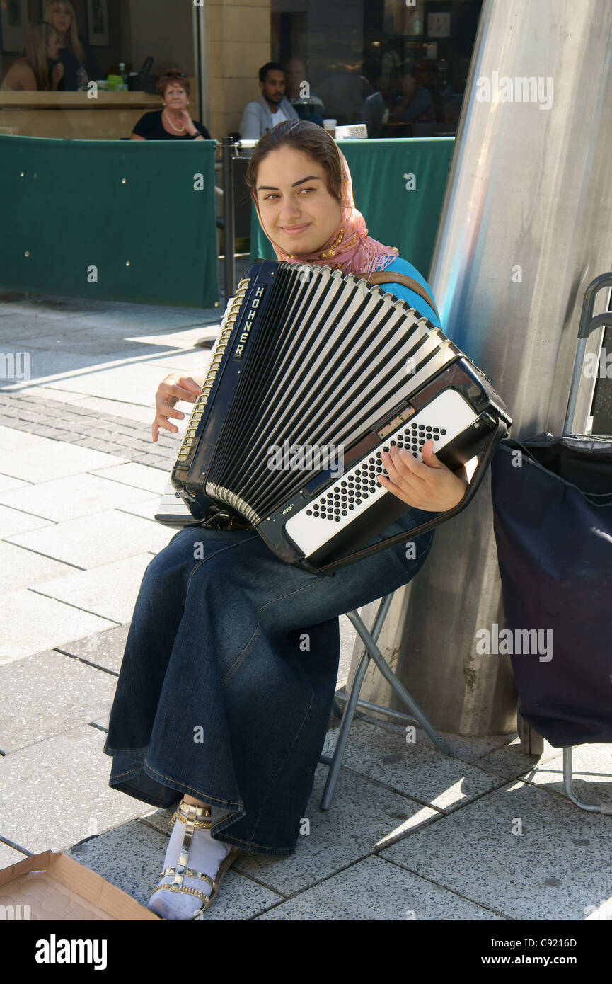 Straßenmusiker spielen ein Akkordeon in der Queen Street, Cardiff, Südwales, UK Stockfoto