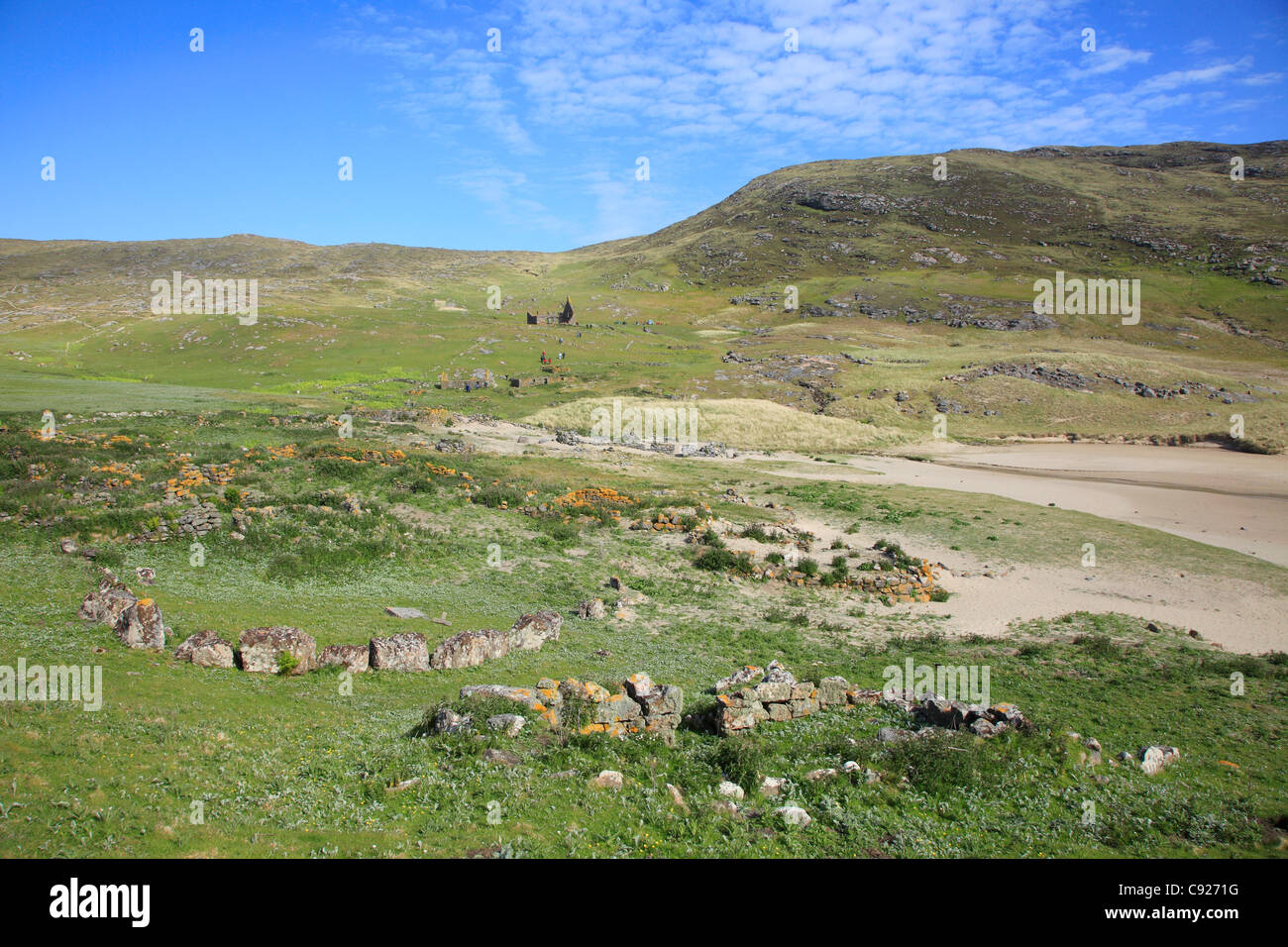 Stein Kruege im Vordergrund und eine verlassene Kirche Ruine in der Distanceon der Insel Mingulay, Schottland. Stockfoto