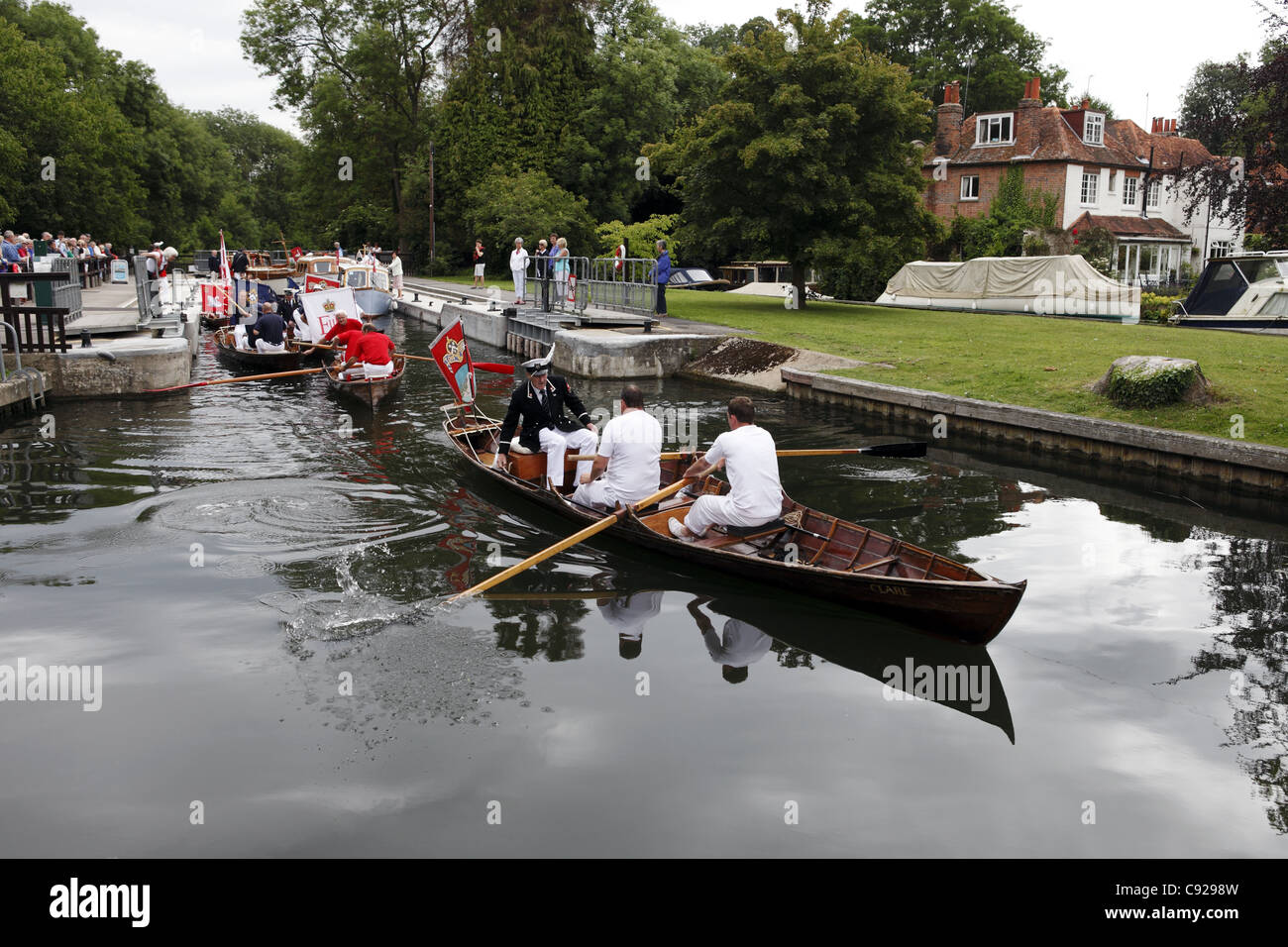 Swan-Oberteil in ihren traditionellen Uniformen Zeile Skiffs den Fluss hinunter, während Swan Upping, Themse, Henley, England Stockfoto