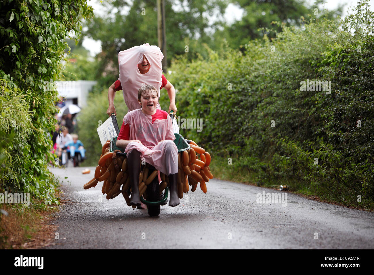 Die schrulligen jährliche Braughing Schubkarre Rennen am Sommerabend in der Dorf-Ford in Braughing in Hertfordshire, England Stockfoto