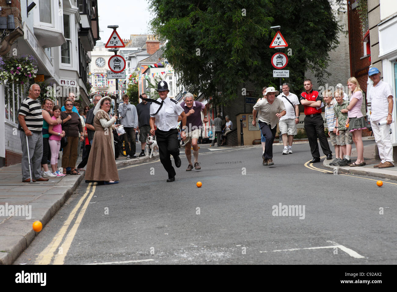 Die schrulligen jährliche Totnes Orange Rennen, statt an einem Sommertag Wochentag Morgen auf der High Street in Totnes, Devon, England Stockfoto